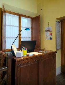 una oficina con un escritorio con una lámpara. en Oliviera Camere, en Pienza