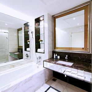 a bathroom with a tub and a sink and a mirror at SKY POOL Luxury Suite 2-4Pax at KL City in Kuala Lumpur