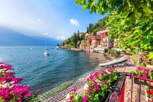 a view of a river with pink flowers and houses at Spa Tiny Love Apartment close to Milan-Como-Malpensa in Saronno