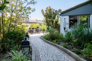 a cobblestone path in front of a house at Hôtel Le Peu Breton in Sainte-Marie-de-Ré