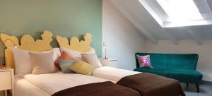 um quarto com uma cama e uma cadeira verde em Residenza Motta em Locarno