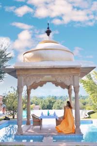 a woman in a yellow dress sitting under a gazebo at Tree of Life Resort & Spa Jaipur in Jaipur