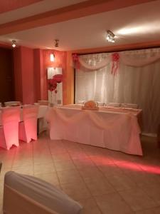 a room with two tables in a room with pink lighting at Giusvalla Forest Village in Dego