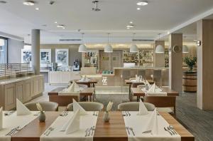 a restaurant with wooden tables and chairs and a cafeteria at Columna Medica in Łask
