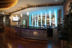 a bar in a restaurant with a counter and chairs at Pearl Hotel & Spa in Umm Al Quwain