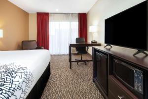 a hotel room with a bed and a flat screen tv at La Quinta by Wyndham Clearwater Central in Clearwater +19 photos