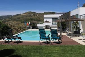 a group of chairs sitting next to a swimming pool at LBV House Hotel in Pinhão