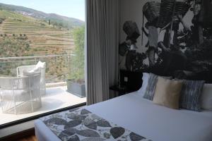 a bedroom with a bed and a window with a view at LBV House Hotel in Pinhão