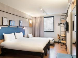 ein Hotelzimmer mit 2 Betten und einer Leiter in der Unterkunft ibis Paris CDG Airport in Roissy-en-France