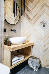 a bathroom with a sink and a wooden wall at Sichlańskie Spanie in Murzasichle