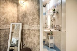 uma casa de banho com um lavatório e um espelho em Santamariarooms em Roma