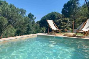 two chairs and a swimming pool with trees in the background at Casa Mira Tâmega in Marco de Canaveses