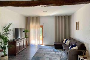 a living room with a couch and a tv at Casa Mira Tâmega in Marco de Canaveses