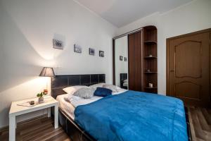 een slaapkamer met een bed met een blauwe deken erop bij Apartment on Virmens`ka Street in Lviv