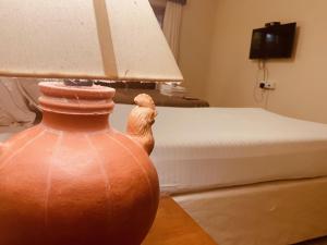 a bedroom with a bed and a vase with a lamp at Pinnacle Holiday Homes in Arpora