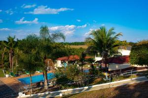 ein Resort mit einem Pool und Palmen in der Unterkunft Hotel Paraíso Dos Alpes in São Pedro