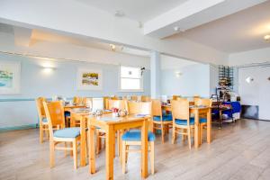 uma sala de jantar com mesas e cadeiras de madeira em OYO Godolphin Arms Hotel em Newquay