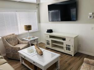 a living room with a table and a tv at Amazing beach getaway pool condo by the beach in Bradenton Beach