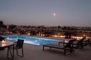 a pool on the roof of a building with tables and chairs at AKA West Hollywood, Serviced Apartment Residences in Los Angeles