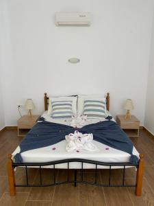 a bed with blue and white sheets and pillows at Grande Blue Suites with private bay in Archangelos