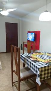 a dining room with a table and a tv at Kitnet Aurora in Miguel Pereira