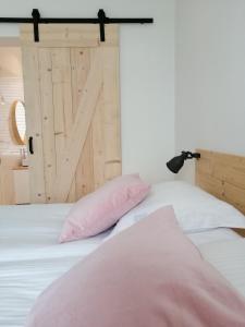 ein Schlafzimmer mit einem weißen Bett und einer Schiebetür aus der Scheune in der Unterkunft Haven 7 in Brügge