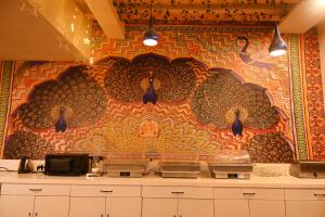una cocina con una pared con un mural colorido en Hotel Heritage Inn at Assi Ghat, en Varanasi