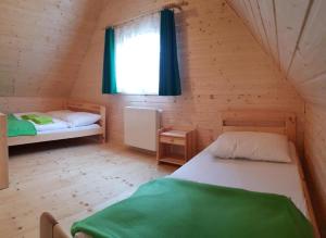 a bedroom with two beds in a wooden cabin at Zielone Domki in Pobierowo