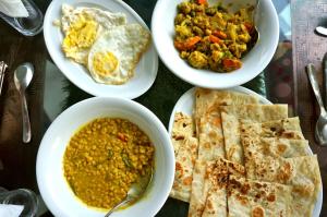 una mesa cubierta con platos de comida con diferentes alimentos en Sreemangal Inn Hotel & Restaurant, en Sreemangal