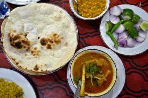 una mesa con platos de comida y un tazón de sopa en Sreemangal Inn Hotel & Restaurant, en Sreemangal