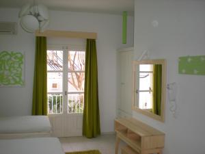 a room with a bed and a window with green curtains at Manolis' House in Skiathos Town