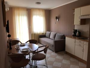 een keuken en een woonkamer met een tafel en een bank bij József Apartments House in Zalakaros