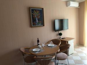 een eetkamer met een tafel en stoelen en een fles wijn bij József Apartments House in Zalakaros