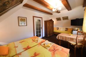 Cette chambre comprend deux lits, une table et un canapé. dans l'établissement Penzion v chaloupce, à Rychnov nad Kněžnou
