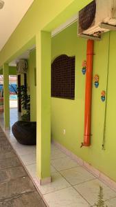 a green wall with a tire on the side of a house at Pousada Cabo Branco in João Pessoa