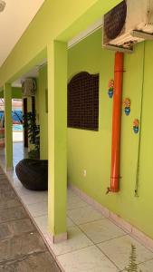una pared verde con un neumático al lado de una casa en Pousada Cabo Branco, en João Pessoa
