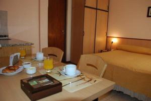 a room with a table with a bed and a table with food at PARQUE APART HOTEL in San Juan