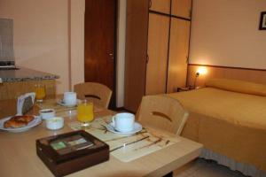 een kamer met een tafel met een bed en een tafel met eten bij PARQUE APART HOTEL in San Juan