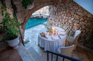 a table with a white table cloth in a stone wall at Covo dei Saraceni in Polignano a Mare