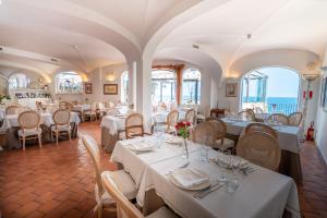 un comedor con mesas y sillas blancas en Covo dei Saraceni, en Polignano a Mare