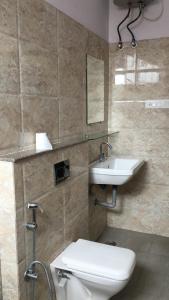 a bathroom with a toilet and a sink at Hotel Trihari in Rishīkesh