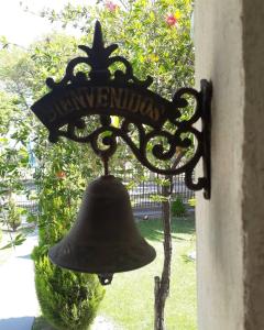 una campana colgando del lateral de un edificio en Shanti Hostel en San Rafael