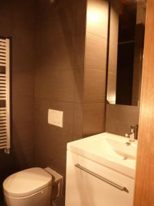 une salle de bain avec des toilettes blanches et un lavabo dans l'établissement L'Auberge de l'éclipse, à Bruxelles
