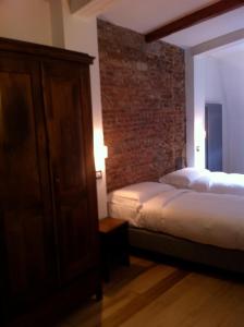 um quarto com uma cama e uma parede de tijolos em L'Auberge de l'éclipse em Bruxelas