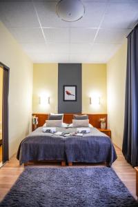 Un dormitorio con una cama grande y una alfombra azul en 4 Évszak Hegyihotel, en Mátraháza