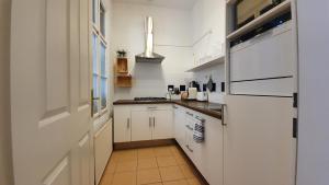 una pequeña cocina con armarios blancos y una ventana en Gorgeous Viennese Apartment 10 min to City Center, en Viena