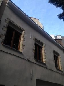 two windows on the side of a building at L'Auberge de l'éclipse in Brussels