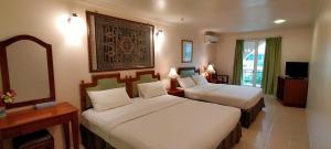 マラッカにあるHotel Johanのベッド2台と鏡が備わるホテルルームです。