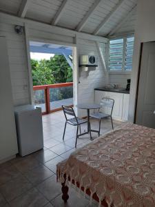 1 dormitorio con mesa y sillas y cocina en Gite de Paulo la source en Pointe-Noire