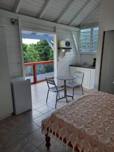 una camera da letto con tavolo e sedie e una cucina di Gite de Paulo la source a Pointe-Noire